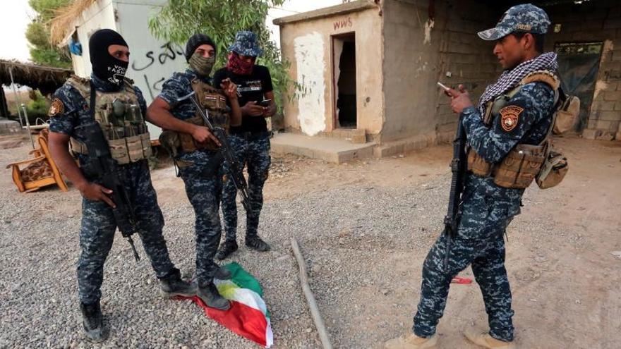 Policías iraquíes pisan la bandera del Kurdistán en Kirkuk.