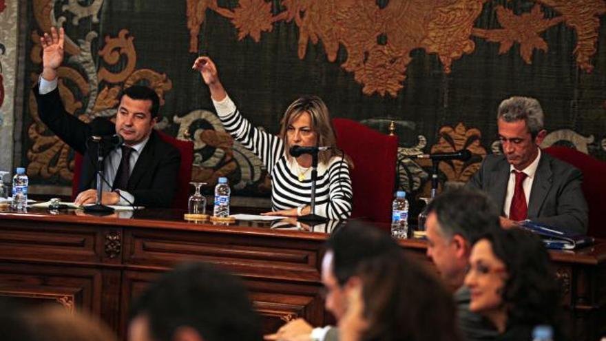 Los populares Castedo y Llorens alzan la mano en el pleno de ayer con el grupo socialista en primer término.