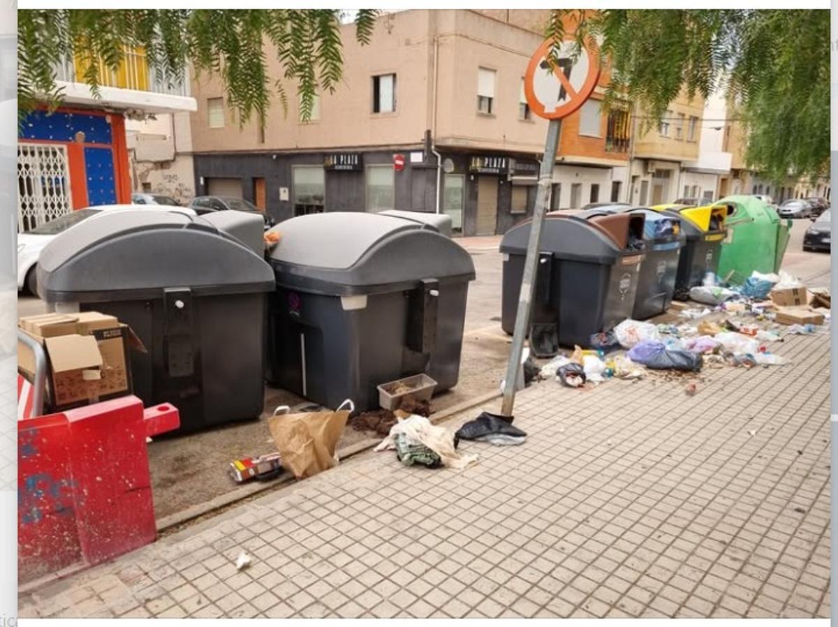 Imagen de unos contenedores movidos y con basura por el suelo.
