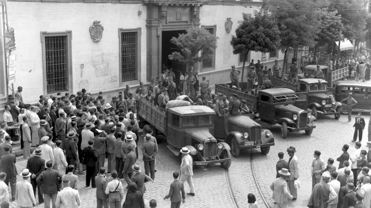 Una serie de camiones cargan detenidos en las puertas de la Audiencia. / Fototeca Municipal de Sevilla