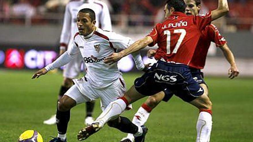 El centrocampista brasileño del Sevilla Adriano Correia Claro  y el defensa del Osasuna Javier Flaño pugnan por una pelota durante el partido correspondiente a la decimoséptima jornada de liga en primera división que Sevilla y Osasuna han disputado hoy en el estadio Ramón Sánchez Pizjuán de Sevilla.