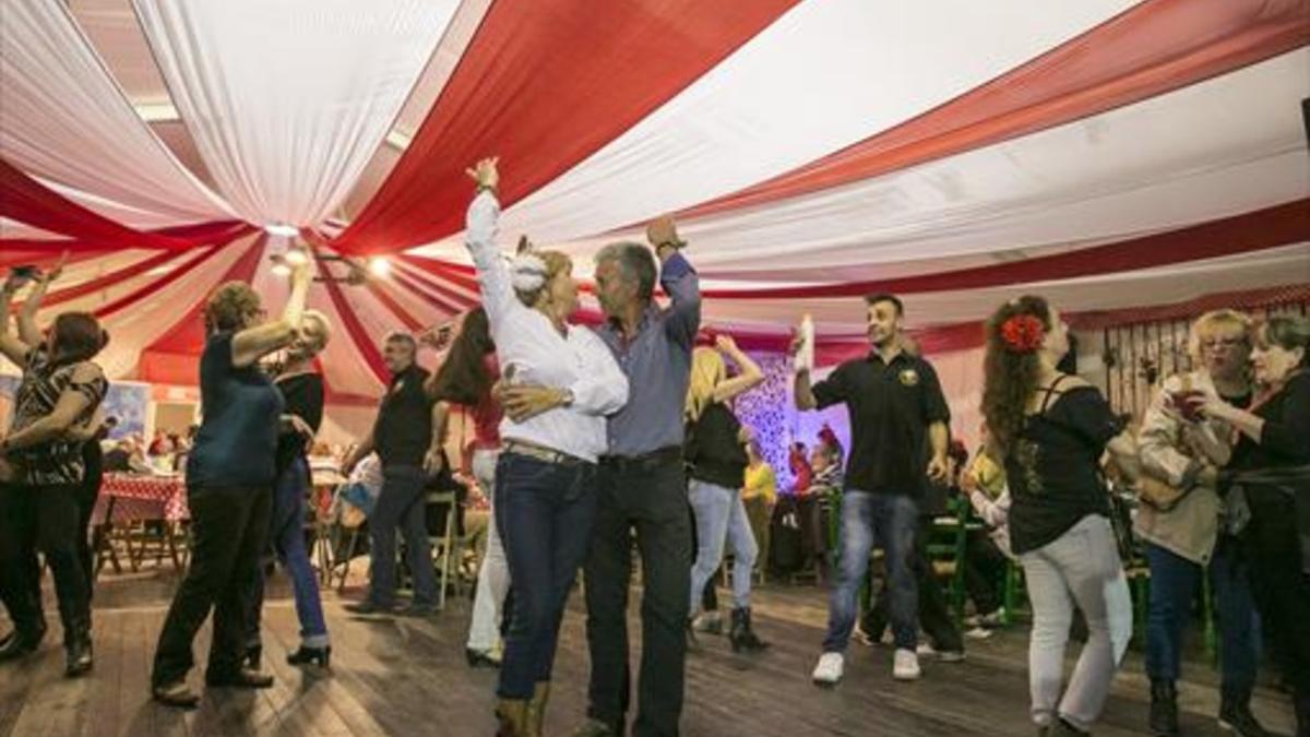 Varias parejas bailan en el interior de una de las casetas de la Feria de Abril, en la edición del 2015.