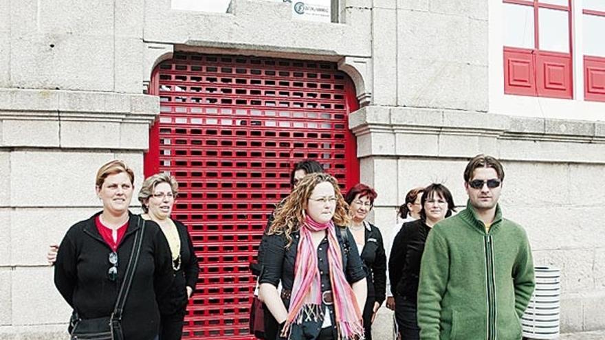 Representantes da asociación, onte, frente á praza.