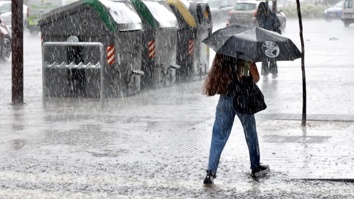Una mujer se protege de la lluvia.