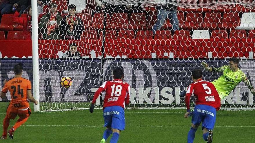 Adrián, a la izquierda, marca de penalti el primero de los tres goles del Eibar en Gijón.