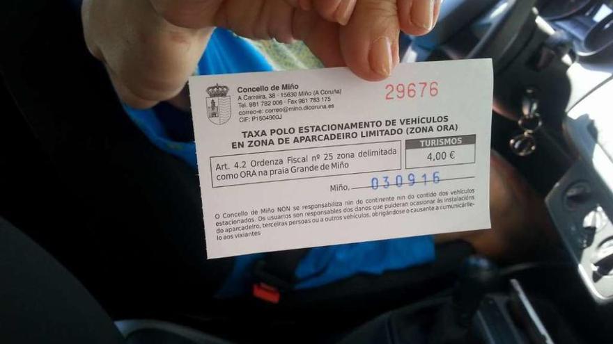 Una mujer enseña el recibo del pago de 4 euros de ORA en el entorno de la playa en pasado 3 de septiembre.