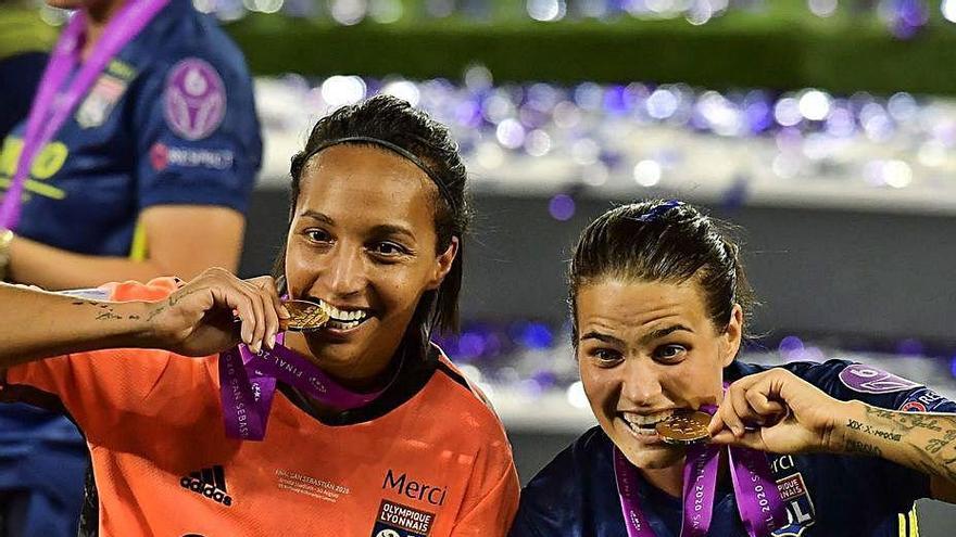 Dos jugadoras del Olympique de Lyon posan con el trofeo.