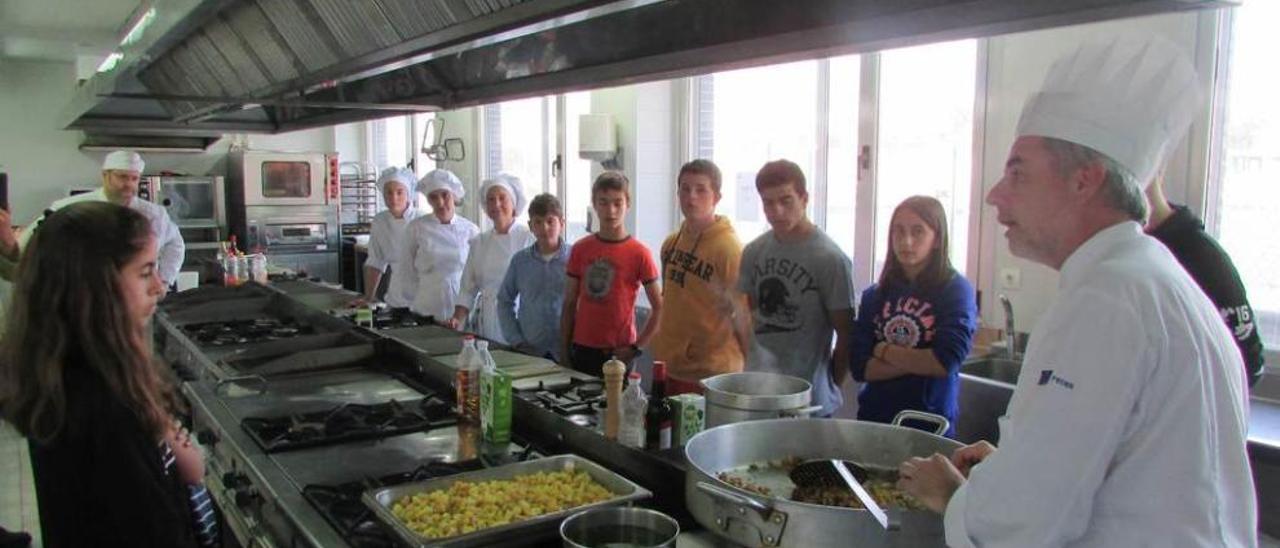 El profesor de Cocina, Jaime Llano, en primer término, da instrucciones antes de preparar los menús con parte de la cosecha de la huerta.