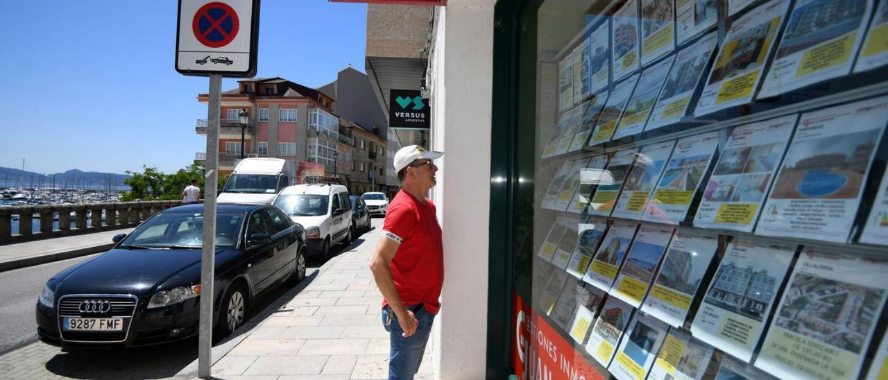 Un hombre mirando las ofertas en una agencia inmobiliaria.