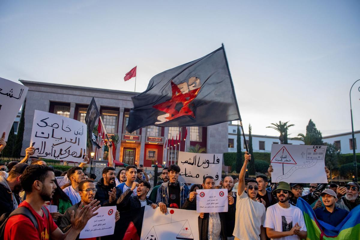 Manifestantes sostienen pancartas y ondean banderas durante una protesta organizada por el colectivo autodenominado 'GenZ 212' en Rabat.
