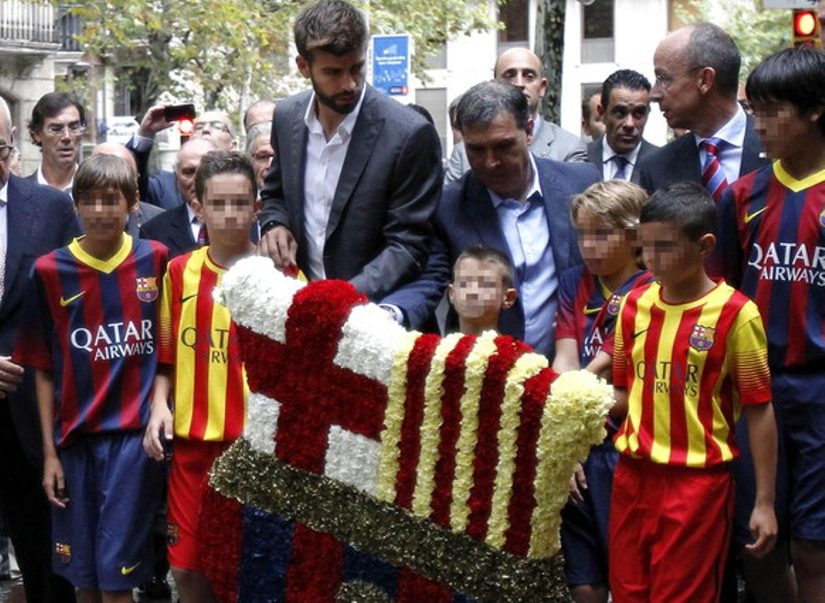 El jugador blaugrana Gerard Piqué i l’entrenador Gerardo Martino, amb un floral escut del Barça.