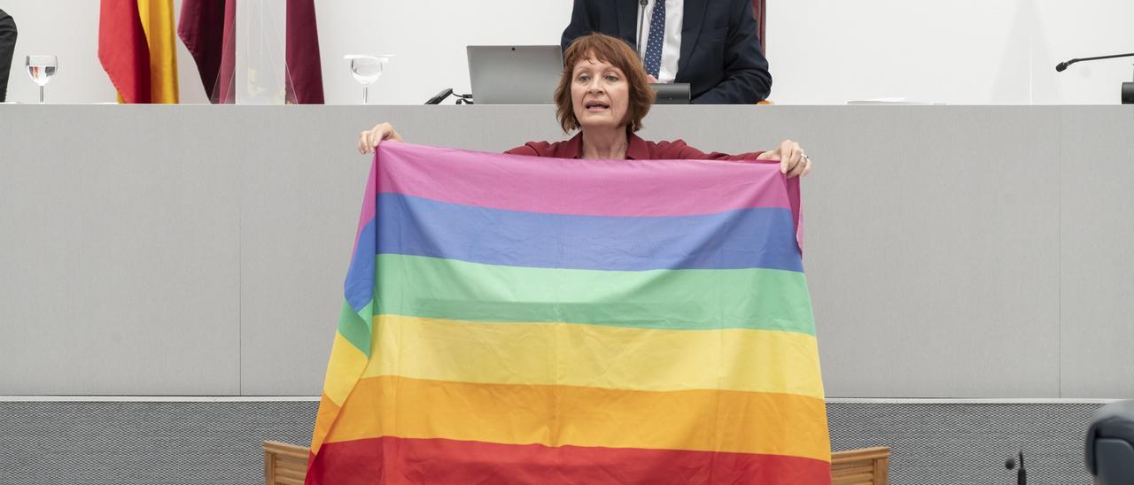 María Marín sujeta la bandera del arcoíris durante el pleno de la Asamblea