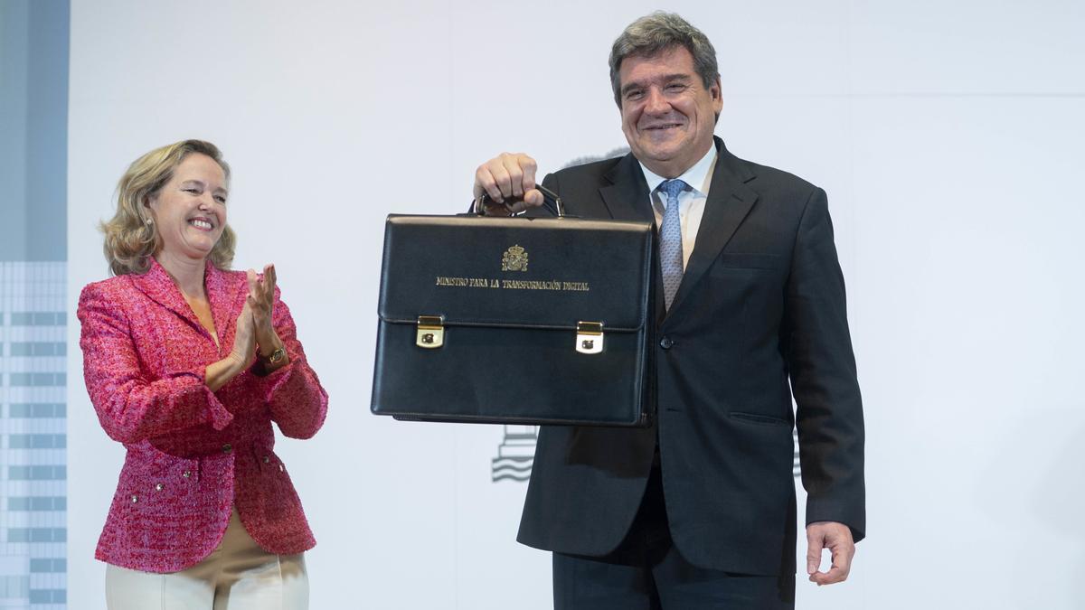 El hasta ahora el ministro de Inclusión, Seguridad Social y Migración, José Luis Escrivá, sujeta su nueva cartera de Transformación Digital, en la sede del Ministerio de Asuntos Económicos y Transformación.