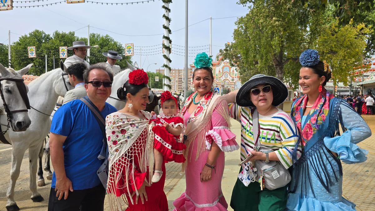 Sevillanas y turistas disfrutando del Jueves de Feria de Sevilla en el Real.
