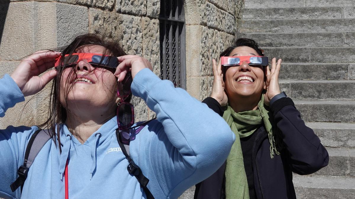 Dos mujeres miran el eclipse en el Tibidabo.