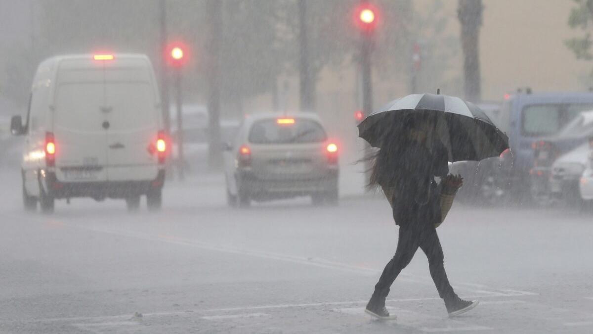 Una mujer camina por la calle bajo la tormenta.