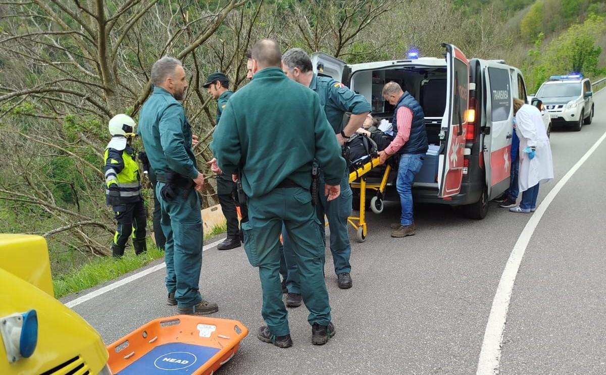 Guardias civiles, bomberos y sanitarios, tras subir a la mujer herida hasta la ambulancia.