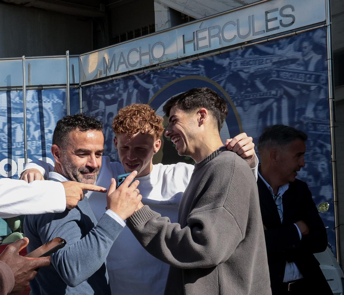 Paco Peña, secretario técnico, y Nico Espinosa, excapitán del Hércules, miran el móvil entre risas durante la despedida de Rubén Torrecilla.