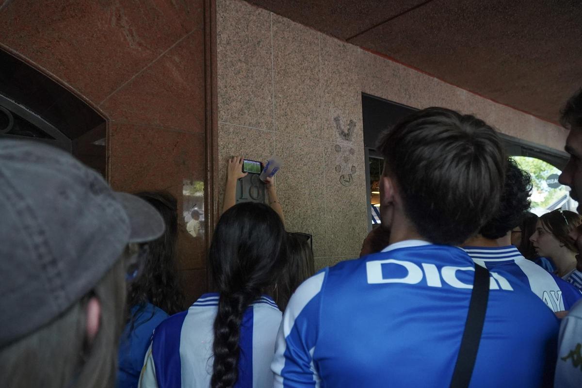 Aficionados ven el partido a través del móvil en los aledaños de Riazor.