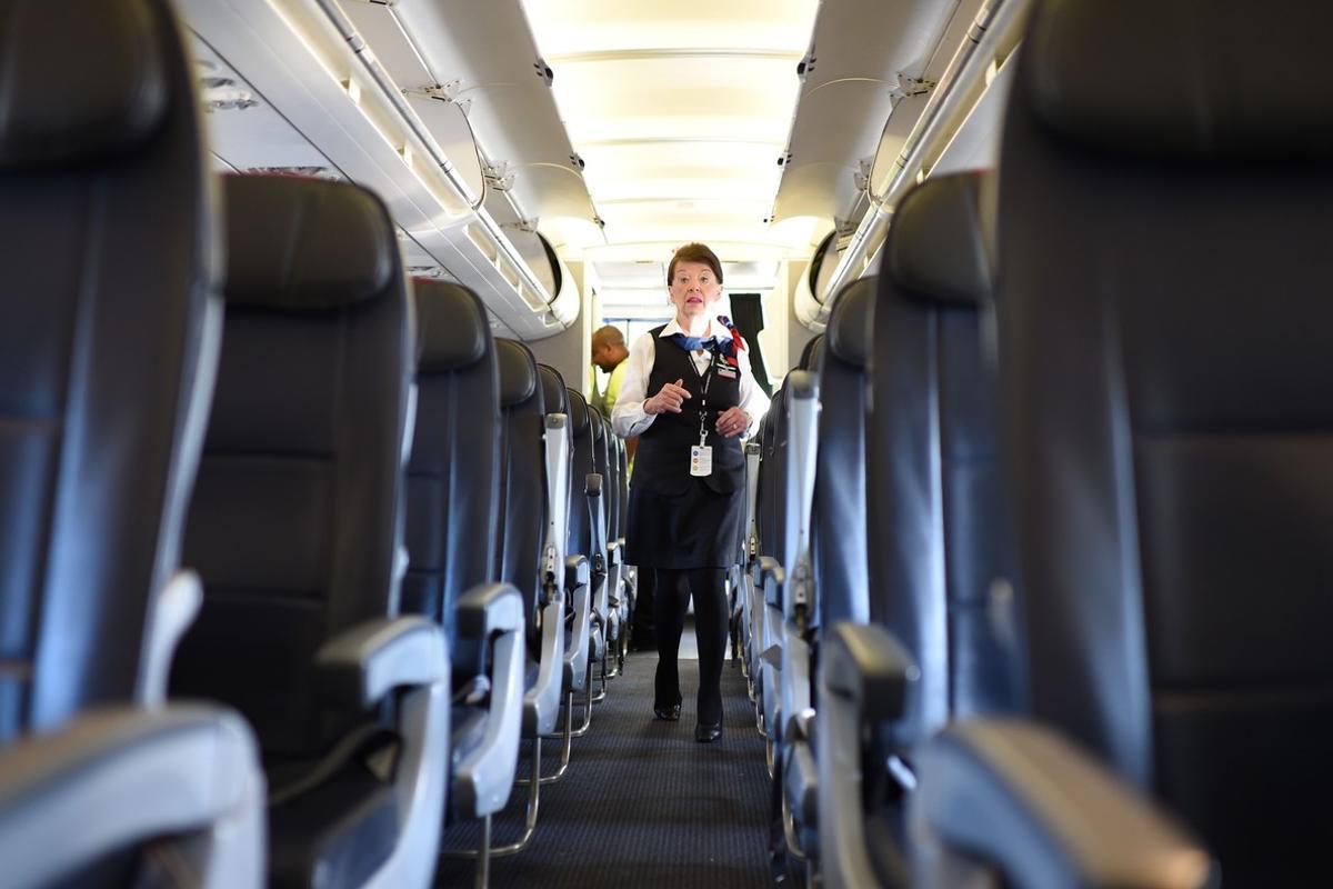 American Airlines longest serving flight attendant, Bette Nash (R), 81 years old, checks the passengers’ seats for forgotten items before disembarking from her daily return flight to Boston at Ronald Reagan Washington Airport in Arlington, Virginia on December 19, 2017.