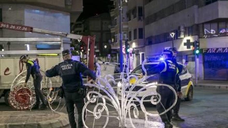 La Policía recoge el arco de luces de Navidad caído en Alfonso el Sabio.