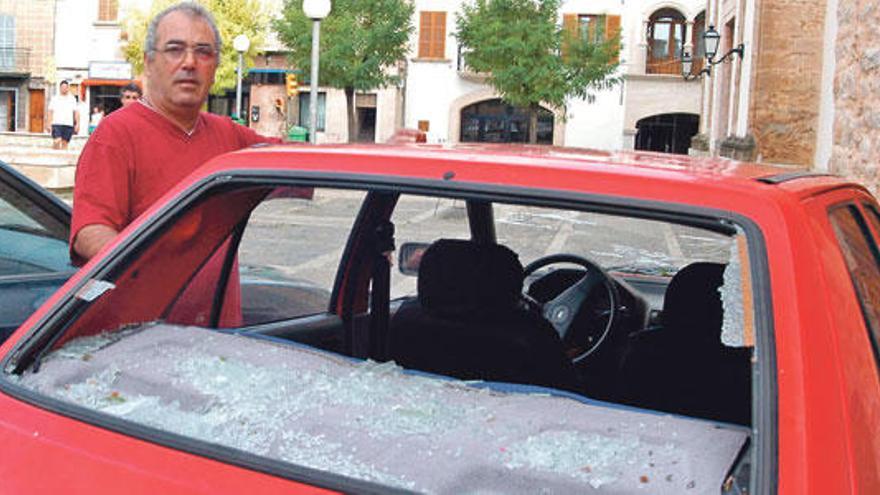 Un vecino de Consell junto a su coche, cuya luna trasera amaneció destrozada por el hielo.