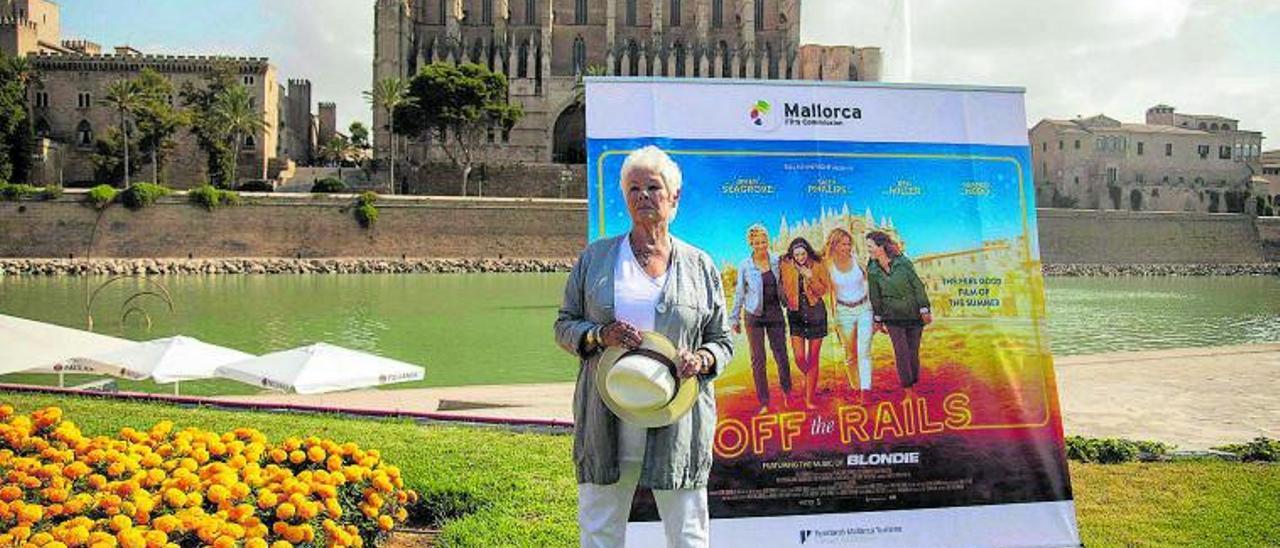Judi Dench posa frente a la Catedral de Palma y un cartel de su última película, Off the Rails, rodada en Mallorca. | GUILLEM BOSCH