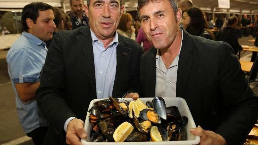 Padín, presidente de Amegrove (i.), muestra unos mejillones. // Muñiz