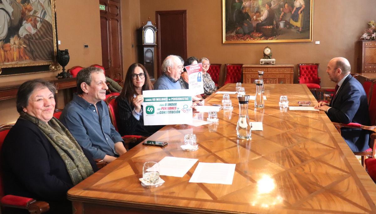 Juan Cofiño, presidente de la Junta (izquierda), frente a Eduardo Madroñal y otros integrantes de la Mesa por el Blindaje de las Pensiones.