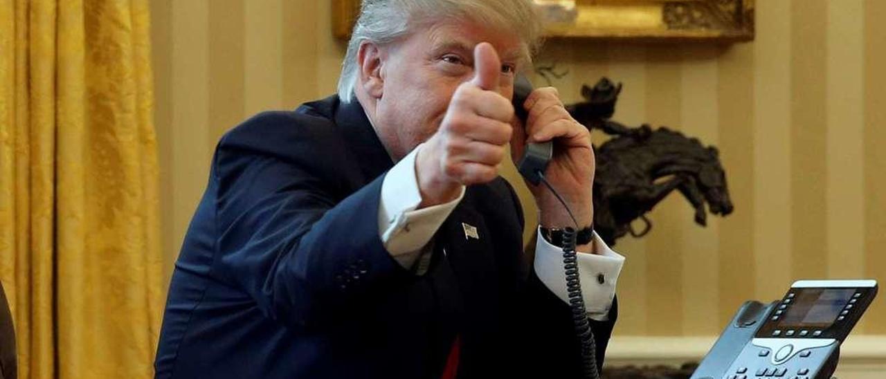 El presidente de EE UU, Donald Trump, alza el pulgar hacia la cámara mientras conversa, ayer, con el rey Salman de Arabia Saudí. // Reuters