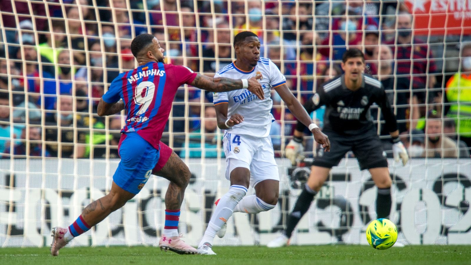 Alaba esquiva la entrada de Memphis en el clásico Barça-Madrid en el Camp Nou.