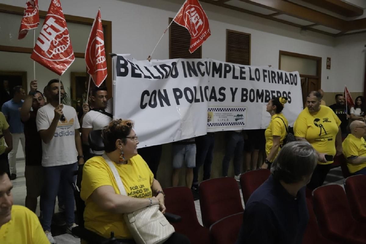Policías y bomberos han desplegado una pancarta durante su protesta en el salón de plenos del Ayuntamiento de Córdoba.