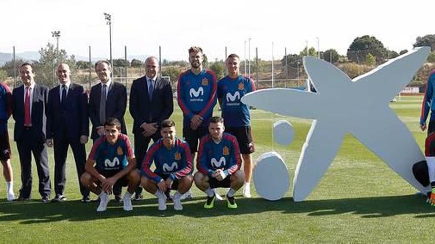 Los jugadores de la selección española con directivos de Caixabank y de la Federación Española de Fútbol.