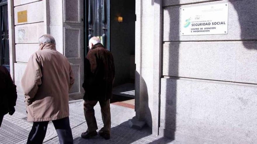 Varios pensionistas pasan junto a la sede del INSS.