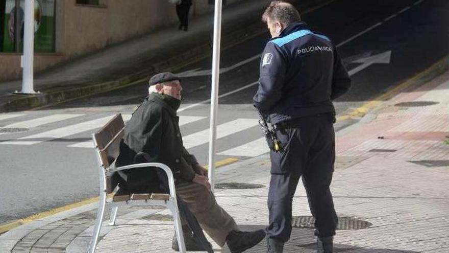 Un policía local advierte a un jubilado de que debe ir a casa. // R. V.