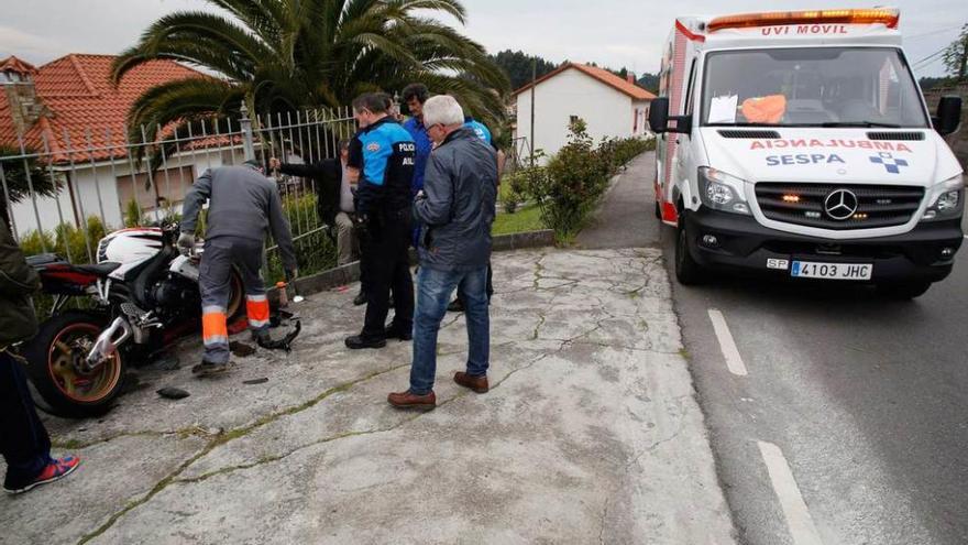 Agentes de la Policía Local, ayer, con la moto siniestrada; a la derecha, la uvi en la que fue atendido el piloto.