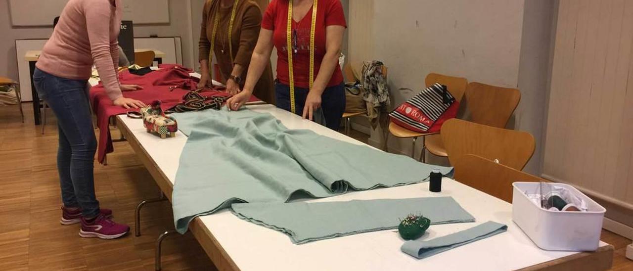 Gabriela Dumitrescu, Juana M.ª Prieto y Paula Fernández elaborando sus trajes de astures en Cangas de Onís.