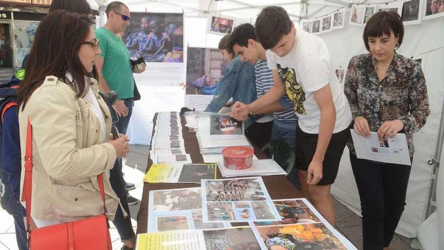 El puesto de venta solidaria de fotos en la Plaza de Galicia atendido por profesores y alumnos del instituto vilagarciano. // Noé Parga