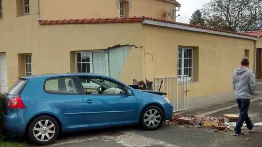 El coche, empotrado contra un lateral de la vivienda.