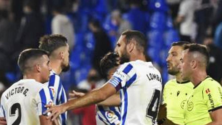 Los jugadores del Málaga CF, pidiendo  explicaciones al colegiado.