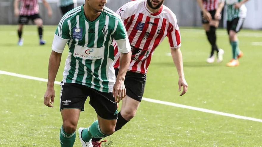 Un jugador del Lenense controla un balón ante la presión de un rival.