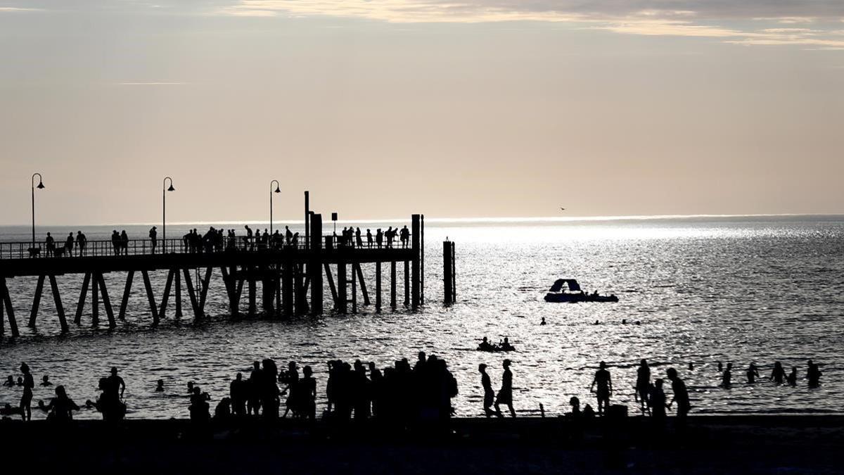 Bañistas en la playa de Gleneig, en Adelaida, al sur de Australia, el 18 de diciembre del 2019, en plena ola de calor