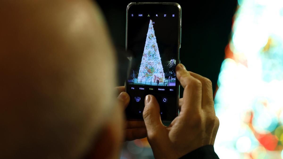 Un hombre fotografía el árbol de Navidad de la plaza Paraíso.