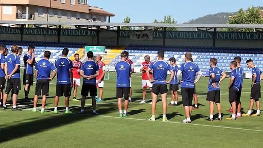 Los futbolistas del Alcoyano, ayer, reciben las primeras instrucciones en el césped de El Collao.