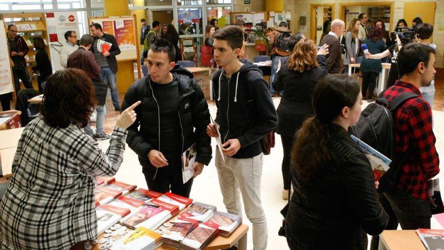 Un grupo de estudiantes busca información sobre posgrados.