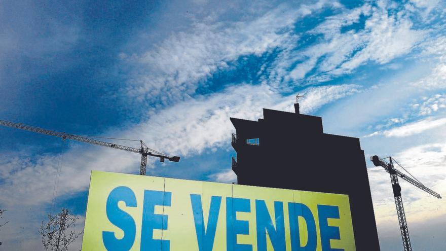 Cartel de ‘Se vende’ frente a un edificio. | // EFE