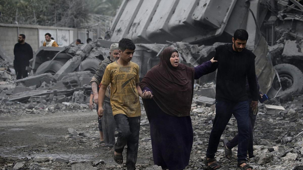 Una familia entre escombros en la Franja de Gaza.