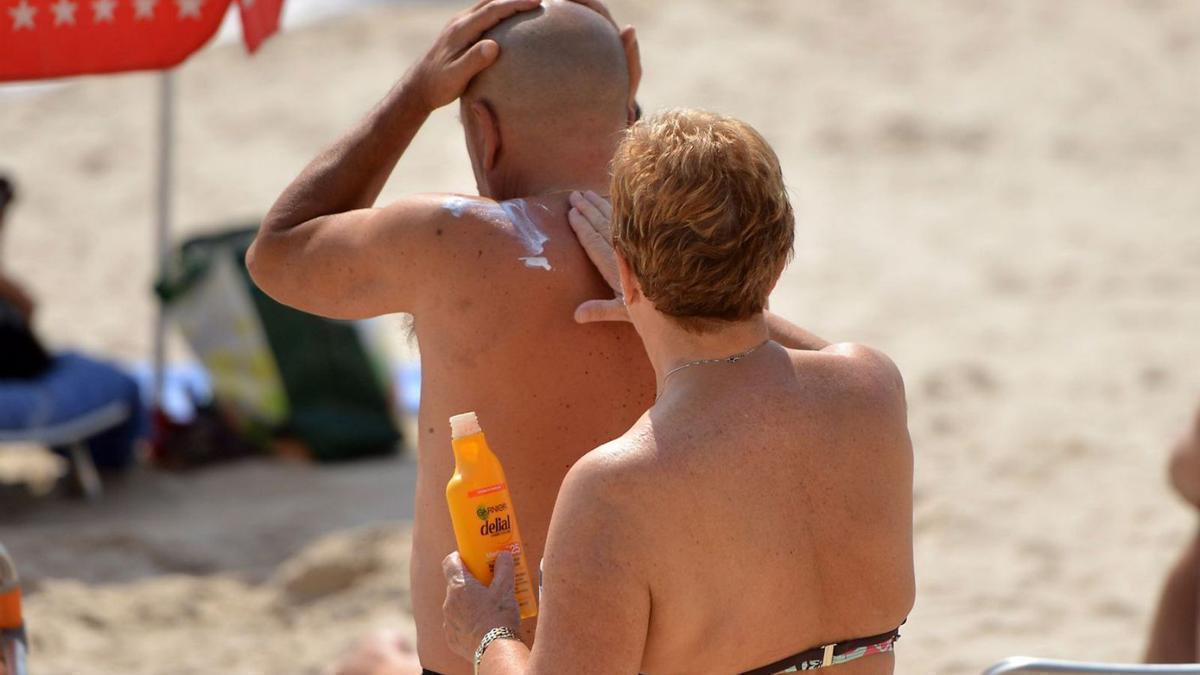 Dues persones posant se crema solar.