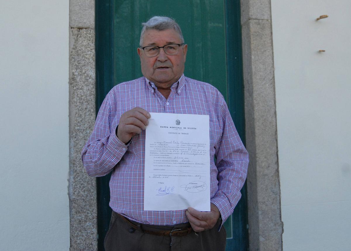 Manolo de Blanco, como é coñecido na parroquia, posa co contrato de hai 50 anos.