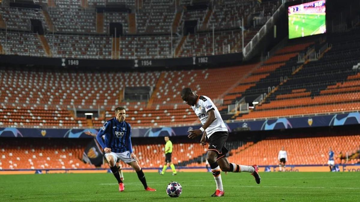 Ilicic y Kondogbia disputan un balón en el Valencia-Atalanta disputado a puerta cerrada.